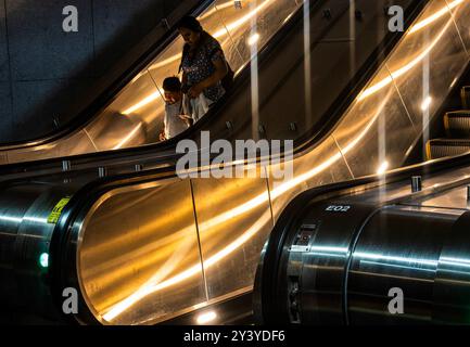 Going down an escalator in a subway station Stock Photo