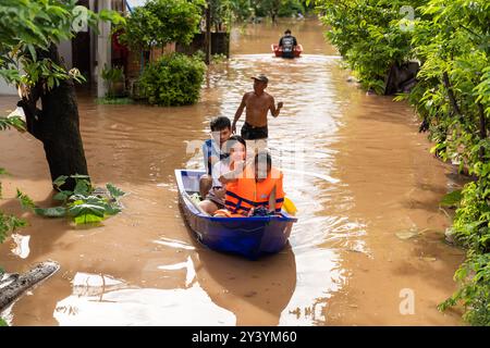 (240915) -- VIENTIANE, Sept. 15, 2024 (Xinhua) -- Local people are evacuated to safe place in boats in Vientiane, Laos, Sept. 14, 2024. Lao authorities issued a notice urging residents in the Lao capital Vientiane to take extra precautions as flood risks increased due to heavy rains and rapidly rising water levels.The level of the Mekong River in Vientiane was recorded at 12.57 meters on Friday, exceeding the danger level of 12.50 meters, according to the Ministry of Natural Resources and Environment. (Photo by Kaikeo Saiyasane/Xinhua) Stock Photo