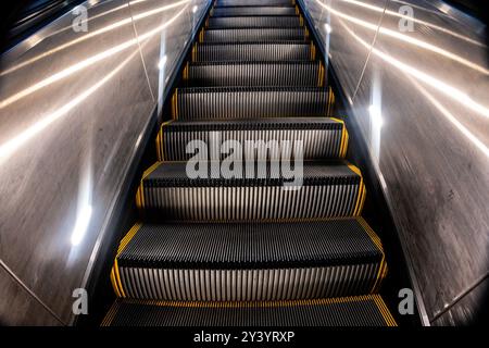 Going down an escalator in a subway station Stock Photo