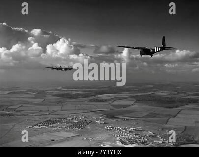 A Handley Page Halifax, four-engine heavy bomber of the Royal Air Force during World War II towing a Hamilcar glider. The largest wooden aircraft constructed during World War IIcould carry diverse loads, such as a Tetrarch Mark IV tank or a Locust tank, two Bren-gun universal carriers or two armored scout cars, a 25-pound gun with tractor, and similar weights. With an ‘all-up’ weight reaching 36,000 pounds (16,329 kilograms), the Hamilcar required an immensely powerful aircraft to tow it and the Halifax became the designated tug. It first took flight on 27th March 1942, and 412 Hamilcars were Stock Photo