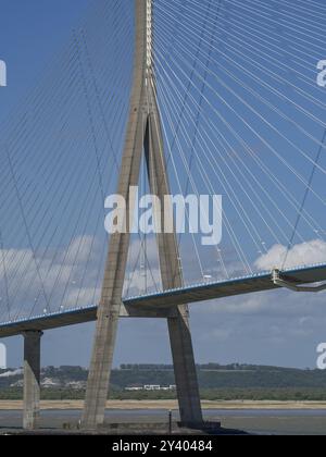 Rope bridge foundation rises into the air, connected by tension cables, with green hill in the background, rouen, its, france Stock Photo