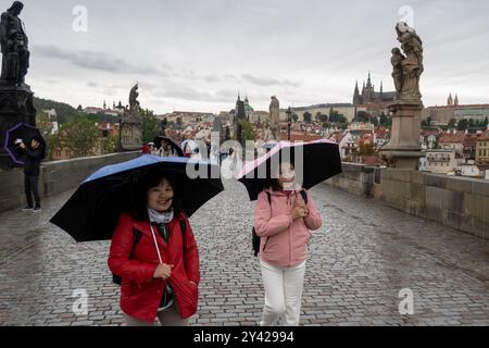 Prague, Czech Republic. 15th Sep, 2024. Women with umbrellas walk along the iconic Charles Bridge in Prague. Heavy rains during the recent days have caused water levels to rise in Vltava river, which caused flood emergency warning. Floods caused by heavy rains have been battering region of central and eastern Europe, including Czech Republic, Poland, Austria, Slovakia and Romania since 13 September 2024. (Credit Image: © Tomas Tkacik/SOPA Images via ZUMA Press Wire) EDITORIAL USAGE ONLY! Not for Commercial USAGE! Stock Photo