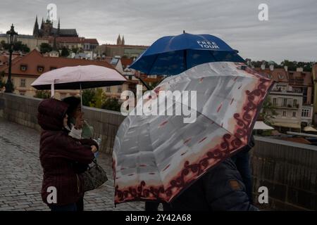 Prague, Czech Republic. 15th Sep, 2024. Group of tourists with umbrellas observe rising water levels of Vltava river on a rainy day in Prague near iconic Charles Bridge and Prague Castle. Heavy rains during the recent days have caused water levels to rise in Vltava river, which caused flood emergency warning. Floods caused by heavy rains have been battering region of central and eastern Europe, including Czech Republic, Poland, Austria, Slovakia and Romania since 13 September 2024. (Photo by Tomas Tkacik/SOPA Images/Sipa USA) Credit: Sipa USA/Alamy Live News Stock Photo