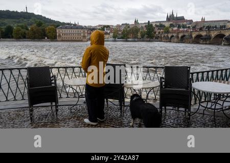 Prague, Czech Republic. 15th Sep, 2024. A man with dog observes the rising water level of Vltava river on a rainy day in Prague near iconic Charles Bridge and Prague Castle. Heavy rains during the recent days have caused water levels to rise in Vltava river, which caused flood emergency warning. Floods caused by heavy rains have been battering region of central and eastern Europe, including Czech Republic, Poland, Austria, Slovakia and Romania since 13 September 2024. (Credit Image: © Tomas Tkacik/SOPA Images via ZUMA Press Wire) EDITORIAL USAGE ONLY! Not for Commercial USAGE! Stock Photo