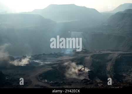 A general view of an open-cast mine, on the outskirts of Dhanbad. Jharia in the Indian state of Jharkhand is home of around 600,000 people. It is situated in the heart of the biggest coal field in the nation. Jharia, which gets its name from the city and region of the same name, is also known for having a terrible rate of coal seam fires, which are one of the main sources of pollution in the environment both locally and worldwide. Massive amounts of carbon dioxide are released into the atmosphere by coal fires. (Photo by Amarjeet Kumar Singh/SOPA Images/Sipa USA) Stock Photo