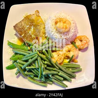 Delicious plate of fresh caught cod fish with prawns in garlic butter with rice and green beans Stock Photo