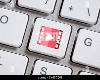 Watching online movies. Online video streaming on internet, content, TV ,concert, show or tutorial. Computer keyboard with multimedia button. Stock Photo