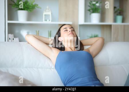 Woman resting and relaxing sitting alone on a sofa at home Stock Photo