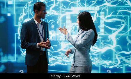 Computer scientists use AI neural networks modeled after human brain to solve complex problems. Startup employees using artificial intelligence to look at data and complete tasks, camera A Stock Photo
