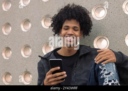 teenager with curly hair using mobile phone Stock Photo