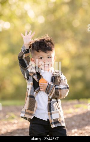 Boy raising hand smiling and looking at the camera Stock Photo