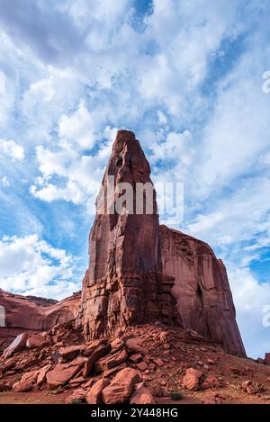 Towering red sandstone spire beneath a vibrant sky in Monument Valley. Stock Photo