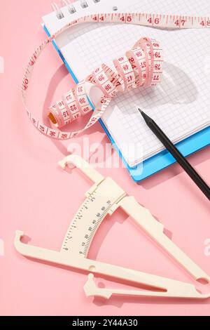 Body fat caliper, measuring tape, vegetables and fruits on table. Diet ...