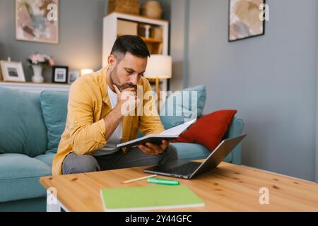 Man working from home and looking at notes Stock Photo