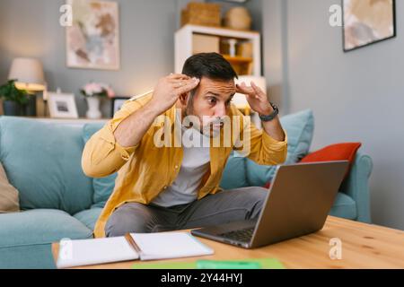 Stressed man dealing with a problem on his laptop Stock Photo