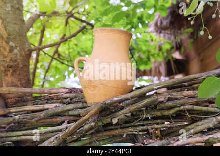 Clay pot on a wicker fence in village. Ethnic design. Traditional countryside. Stock Photo