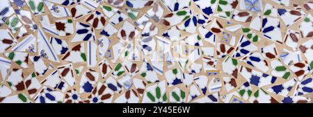 Abstract mosaic of roughly broken tiles on a light brown wall Stock Photo