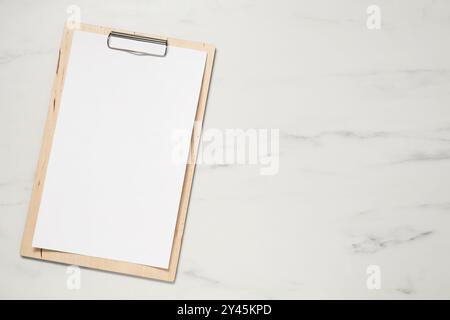 Clipboard with empty paper on white marble table, top view. Mockup for design Stock Photo