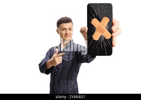 Young male worker holding a smartphone with cracked screen and bandage and pointing isolated on white background Stock Photo