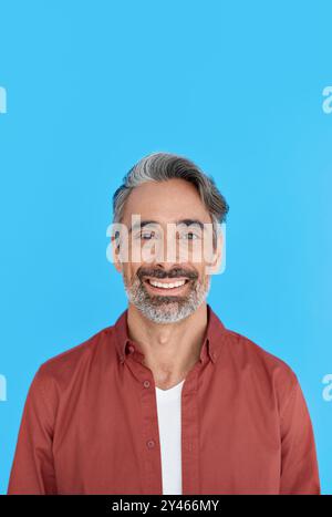 Happy mature casual man standing isolated on blue background. Portrait. Stock Photo