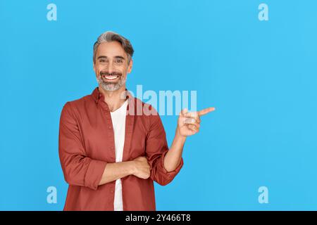 Happy middle aged mature casual man customer pointing finger showing aside. Stock Photo