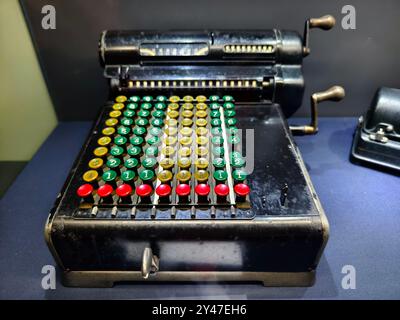 An old fashioned adding machine features a drawer located underneath it Stock Photo