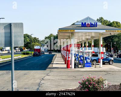 NORWALK, CT, USA- SEPTEMBER 13, 2024: Busy gas station in suburban area with multiple vehicles refueling during sunny morning on I 95 Darien North Stock Photo