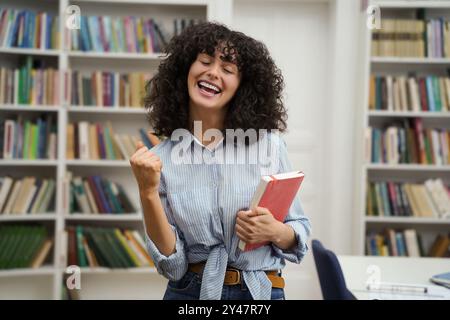 Cute dark-haired young woman looking happy and excited Stock Photo