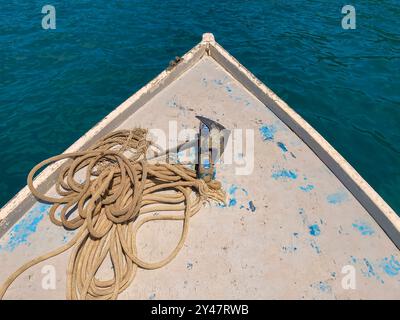 Bow of fishing boat with anchor and rope in turquoise blue sea. Paraty, Brazil. Stock Photo