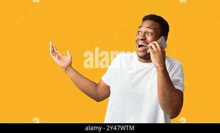 Surprised black guy talking on the phone and gesturing Stock Photo