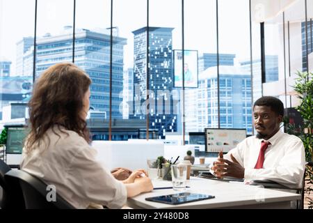 Employee in wheelchair doing business meeting with coworker in office. Person with paraplegia feeling dignified by diversity, inclusion and equal opportunities for people with disabilities at work Stock Photo