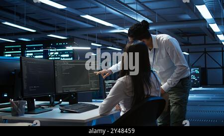 Computer scientists in data center managing and maintaining databases, ensuring data integrity and security. IT staff members updating server room systems using, camera B Stock Photo
