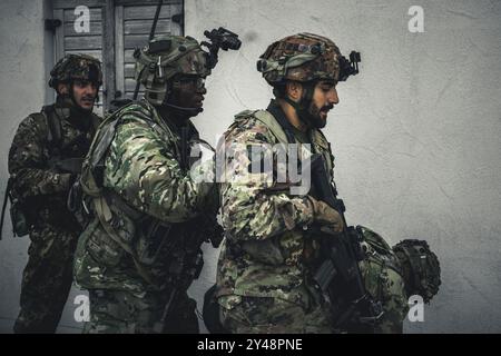 A U.S. Army paratrooper assigned to the 173rd Airborne Brigade conducts a simulated attack with Italian troops with the Paratroopers Brigade 'Folgore' during a final battle in Hohenfels, Germany as part of exercise Saber Junction 24, Sept. 13, 2024.    Saber Junction 24 is a multinational rotational exercise designed to assess the readiness of the U.S. Army's 173rd Airborne Brigade to execute unified land operations in a joint, combined environment and to promote interoperability with more than 4,500 participants from the U.S. and Allied and partner nations at  Hohenfels training area.    The Stock Photo