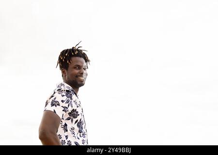 stylish young black man with flower shirt smiling Stock Photo