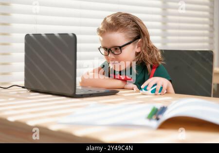Schoolboy studying homework math during her online lesson at home ...