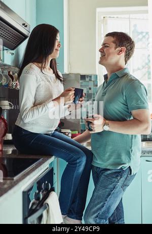 Happy couple, care and chat with coffee, bonding and together for weekend or relaxing in home. Married people, connection and affection as partner in Stock Photo