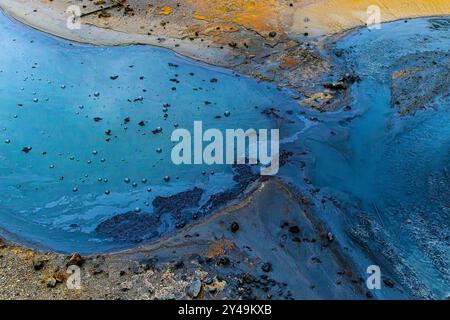 A body of dense water with a dark blue color and a few rocks in it. The water is murky and has a strange smell Stock Photo