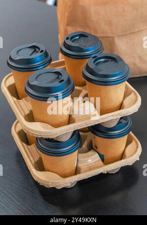 A stack of coffee cups with lids on top of each other. The cups are in a paper tray, ready to take away Stock Photo