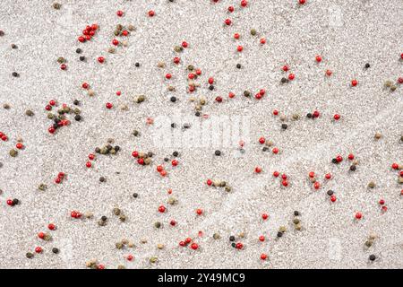 Multicolored peppercorns on a stone gray background. Stock Photo