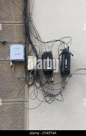 Electric cables on the facade of a building. Stock Photo