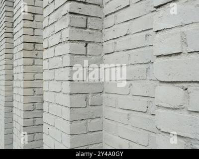 The photo shows a white washed house wall with regular projections. The texture of the wall is well-suited as a background or for design elements. Stock Photo