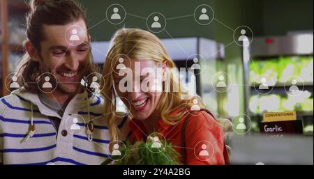 Image of data processing with icons over caucasian couple grocery shopping Stock Photo