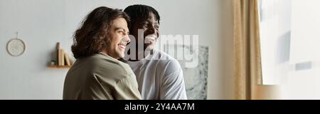Two joyful men share a heartfelt embrace, smiling warmly in their inviting living space. Stock Photo