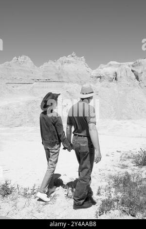 Caucasian couple, aged 55 to 60, walking along a scenic trail at Badlands National Park, Interior, South Dakota, USA. Stock Photo