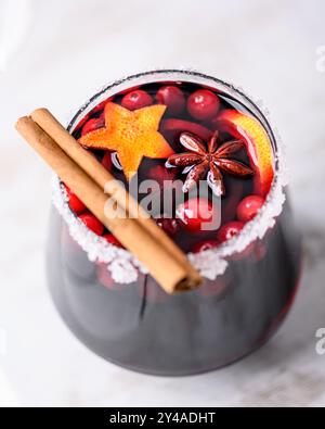 Christmas drink - red spiced mulled wine in glass with slices of orange, cinnamon, star anise and cranberries Stock Photo