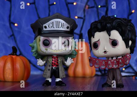 Funko Pop action figures of Beetlejuice and Edward Scissorhands from Tim Burton dark fantasy films. Blue fog, lights, Halloween pumpkins. Stock Photo