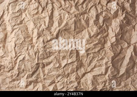 crumpled brown paper surface, brownish tone wrinkled sheet of paper background or backdrop texture, copy space for text Stock Photo