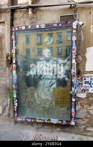 Banksy artwork on a wall in Naples, Italy, featuring an image of the Virgin Mary with a gun Stock Photo