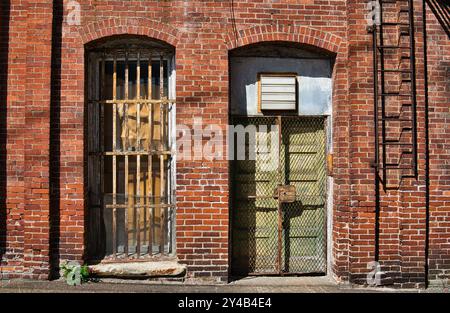 Old door and window with bars on an abandoned building Stock Photo