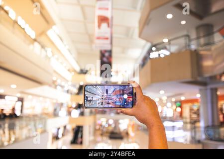 A man taking photo of supermarket with Smartphone. the man is seen using his cellphone to take pictures of objects around him Stock Photo